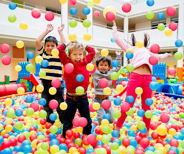Happy group of kids playing at a ball pool